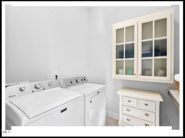 washroom featuring laundry area, baseboards, and separate washer and dryer