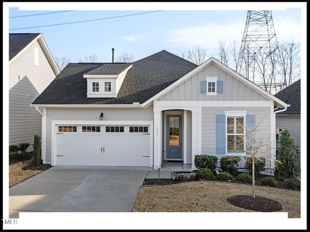 view of front of home with board and batten siding, concrete driveway, a garage, and a shingled roof