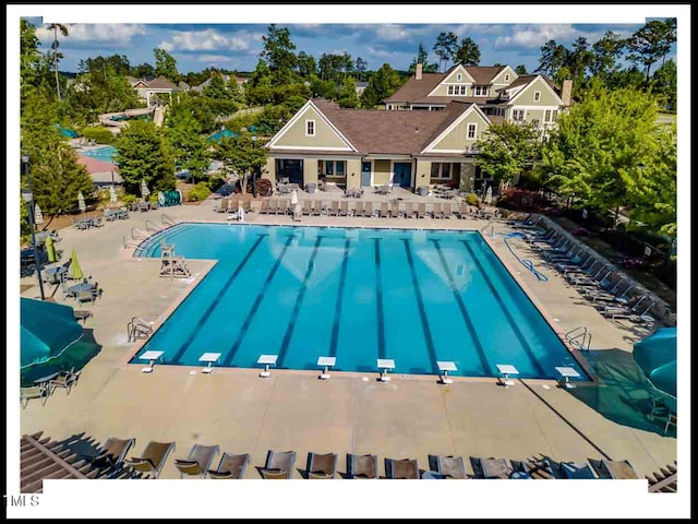 community pool featuring a diving board, a patio, and fence