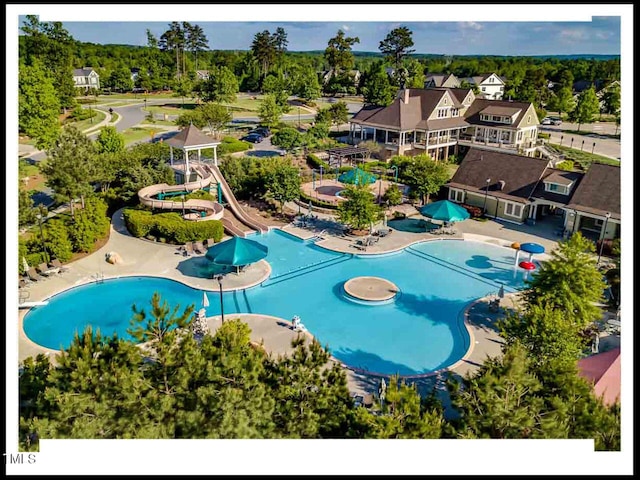 community pool with a patio area and a water slide