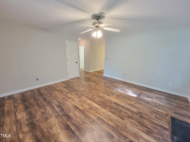 empty room featuring dark wood-type flooring and ceiling fan