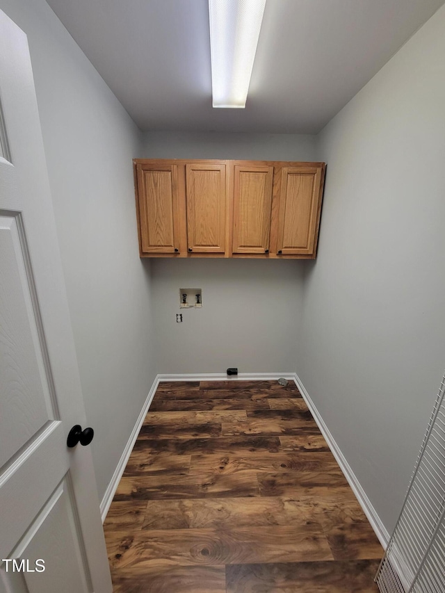 laundry area featuring cabinets, hookup for a washing machine, and dark hardwood / wood-style floors