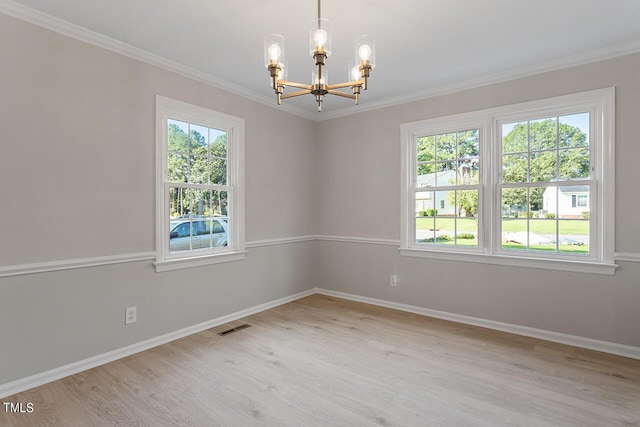 unfurnished room featuring an inviting chandelier, crown molding, plenty of natural light, and light hardwood / wood-style floors