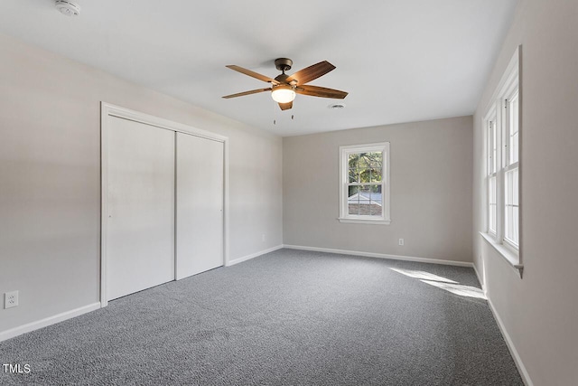 unfurnished bedroom featuring carpet, ceiling fan, and a closet