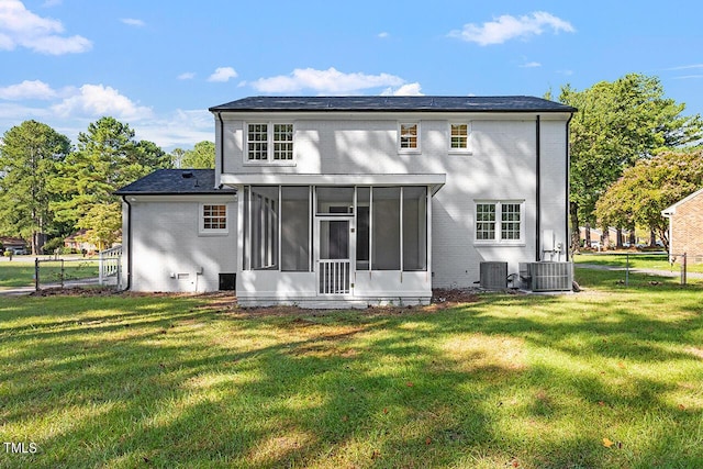 back of house featuring a sunroom, central AC, and a lawn