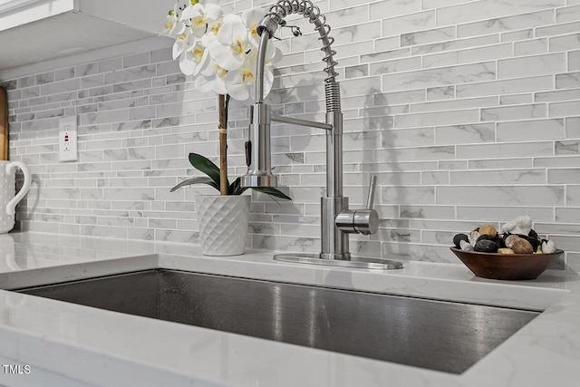 room details with decorative backsplash and a sink