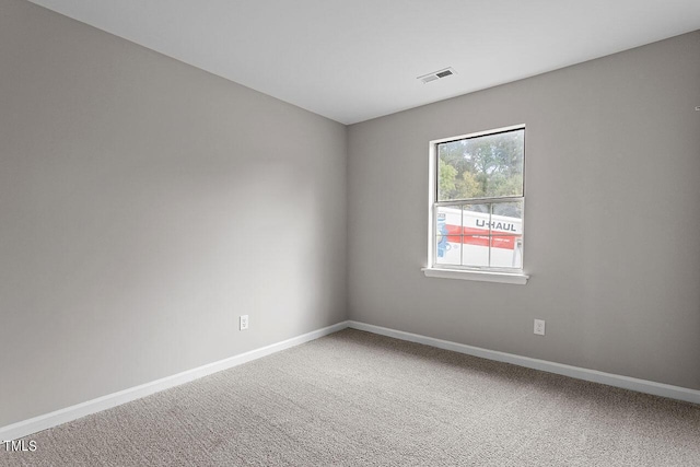 carpeted spare room with baseboards and visible vents