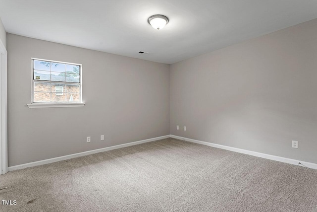 carpeted empty room with visible vents and baseboards