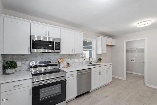 kitchen featuring tasteful backsplash, stainless steel appliances, sink, and white cabinets