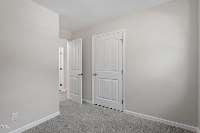 unfurnished bedroom featuring light carpet