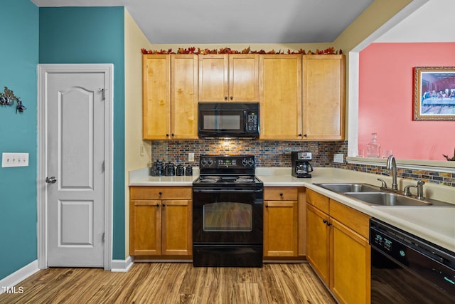 kitchen featuring sink, black appliances, tasteful backsplash, and light hardwood / wood-style flooring