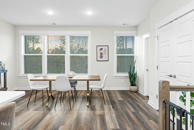 dining room with a wealth of natural light, dark wood-style flooring, and baseboards