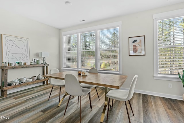 dining area featuring baseboards, wood finished floors, and a healthy amount of sunlight