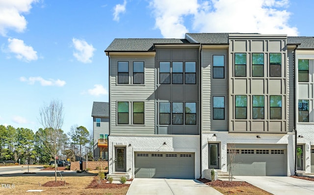 view of property featuring concrete driveway and an attached garage