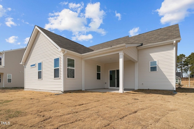 back of house with a yard and a patio