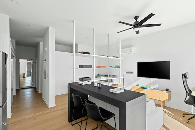 office with light wood-type flooring, ceiling fan, and a wall mounted AC