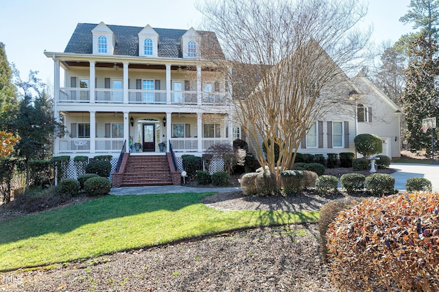 view of front of property featuring a front lawn, a balcony, and a porch