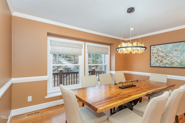 dining area with a notable chandelier, wood finished floors, baseboards, and ornamental molding