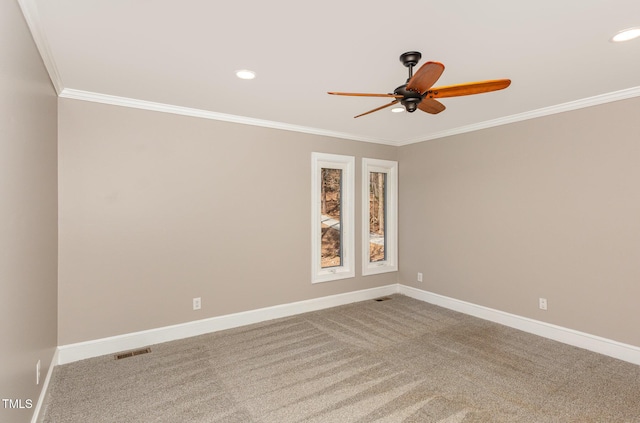 carpeted empty room with visible vents, baseboards, crown molding, and ceiling fan