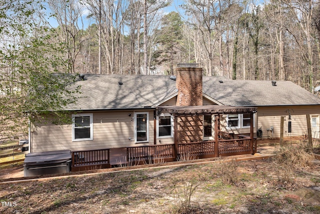 back of property with a shingled roof, a deck, a chimney, and a pergola