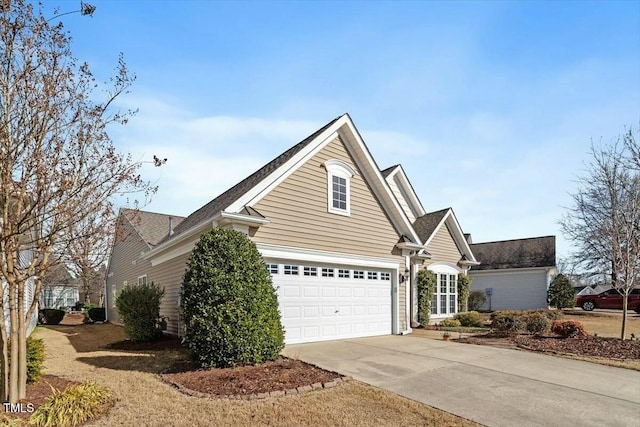 view of side of property featuring a garage and driveway