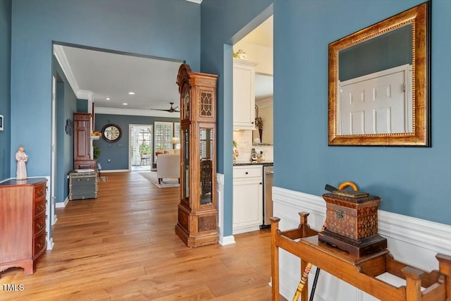 hallway featuring recessed lighting, baseboards, crown molding, and light wood-style floors