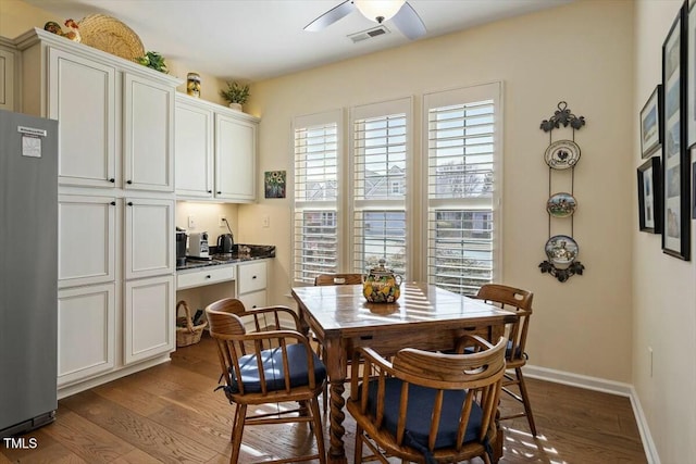 dining space with a ceiling fan, visible vents, baseboards, and dark wood-style flooring