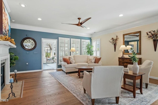 living room featuring plenty of natural light, wood finished floors, a fireplace, and crown molding