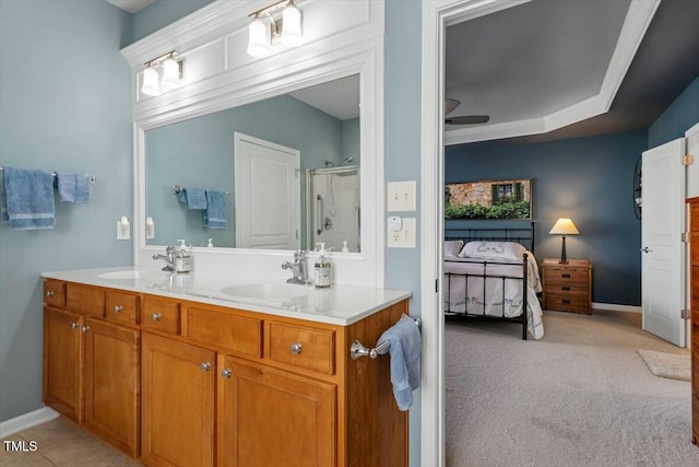 ensuite bathroom featuring double vanity, a stall shower, ensuite bathroom, and a sink