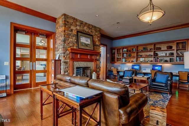 living room with a fireplace, wood finished floors, and ornamental molding