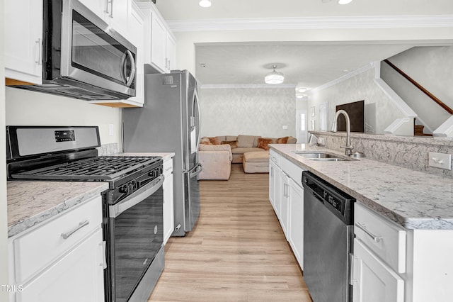 kitchen with white cabinetry, ornamental molding, stainless steel appliances, and sink