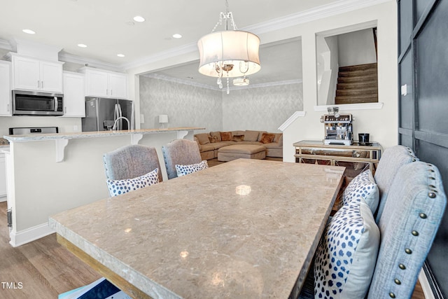 dining area featuring crown molding and light hardwood / wood-style floors