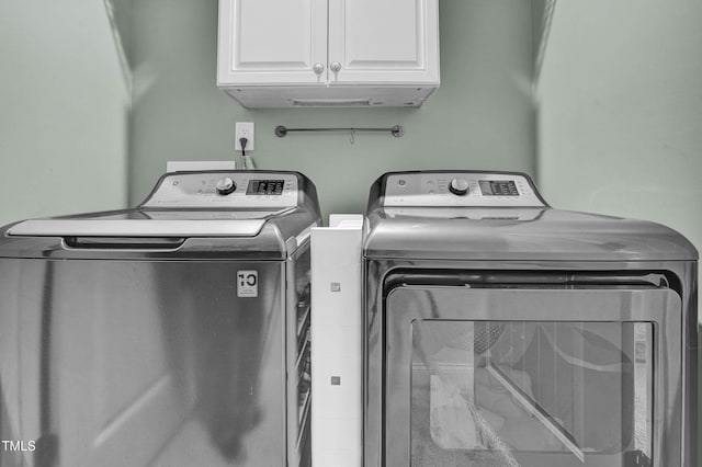 laundry room with cabinets and washing machine and clothes dryer