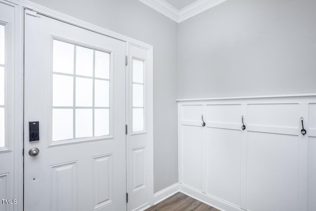 doorway featuring a wainscoted wall, dark wood-style floors, a decorative wall, and crown molding