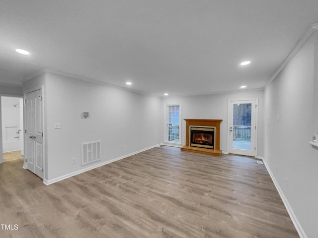 unfurnished living room featuring crown molding and light hardwood / wood-style floors