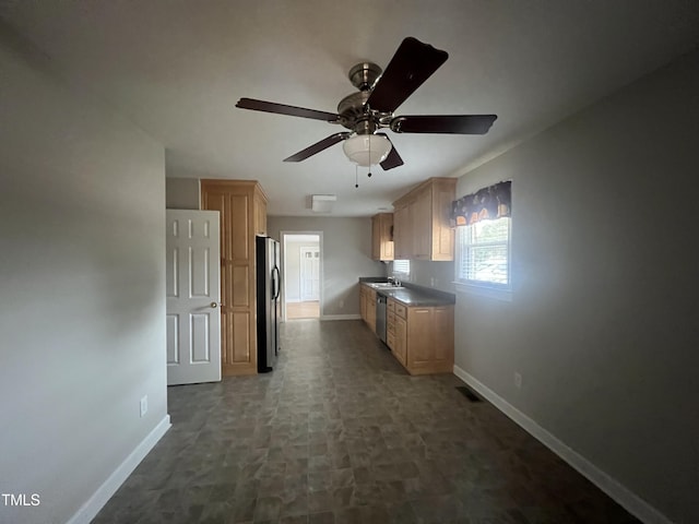 kitchen featuring ceiling fan, stainless steel appliances, light brown cabinetry, and sink