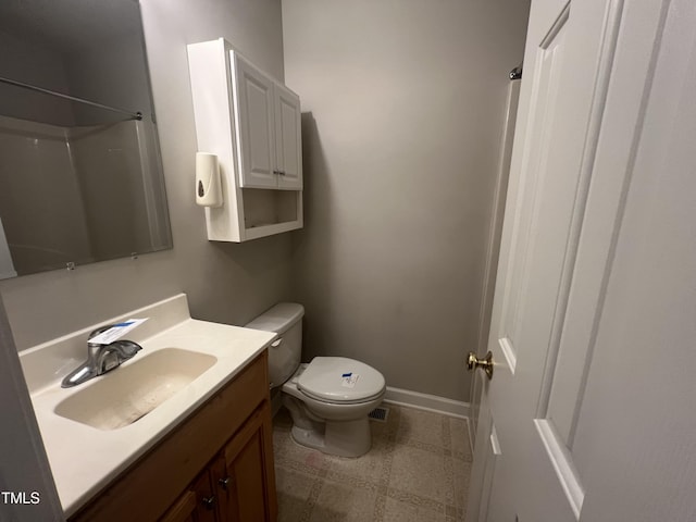 bathroom with vanity, a shower, and toilet