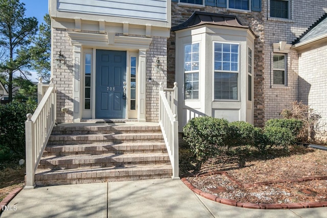 view of exterior entry featuring brick siding