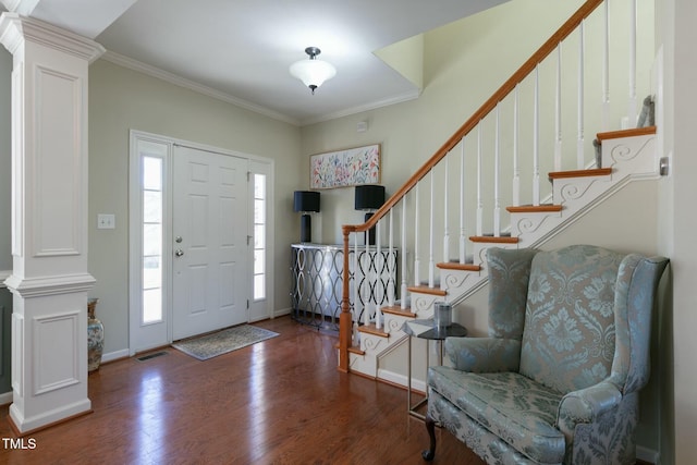 entrance foyer with crown molding, decorative columns, stairway, wood finished floors, and baseboards