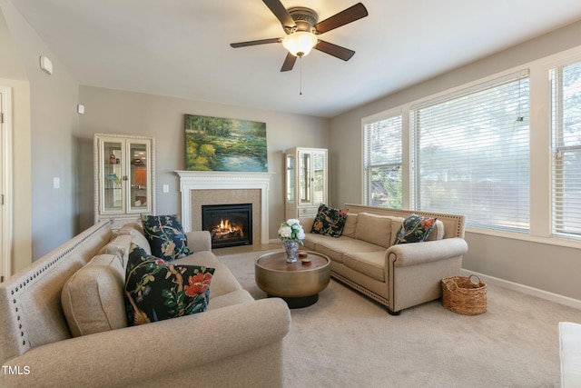 carpeted living area featuring ceiling fan, a fireplace with flush hearth, and baseboards