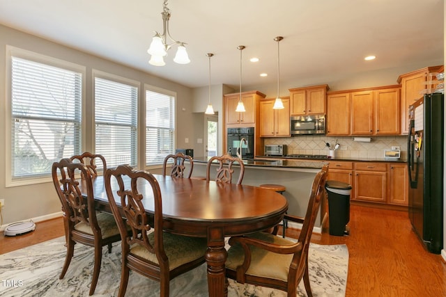 dining room featuring baseboards, recessed lighting, wood finished floors, and a notable chandelier