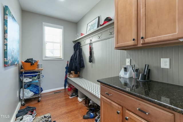 mudroom with wood finished floors, visible vents, and baseboards