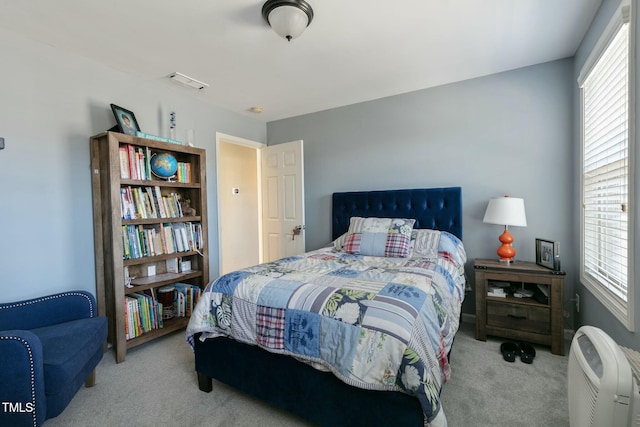 bedroom featuring multiple windows, visible vents, and carpet flooring