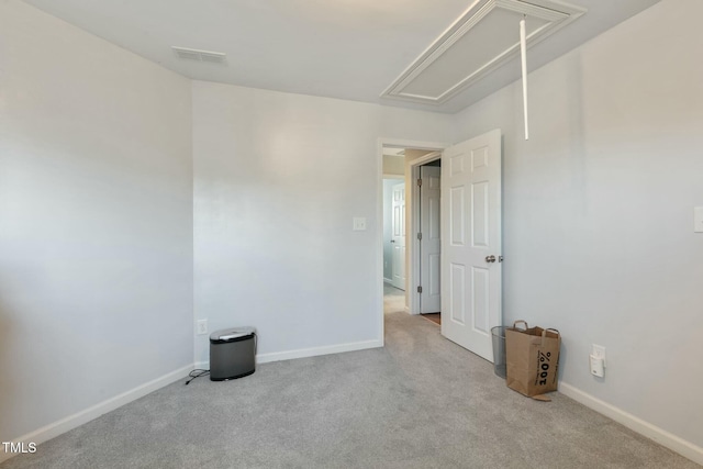 empty room featuring visible vents, carpet flooring, attic access, and baseboards