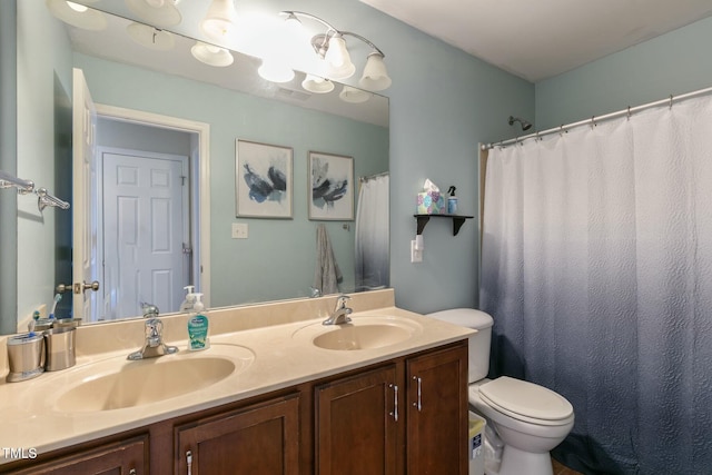 bathroom featuring toilet, double vanity, a sink, and visible vents