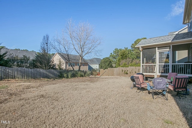 view of yard with fence and a sunroom