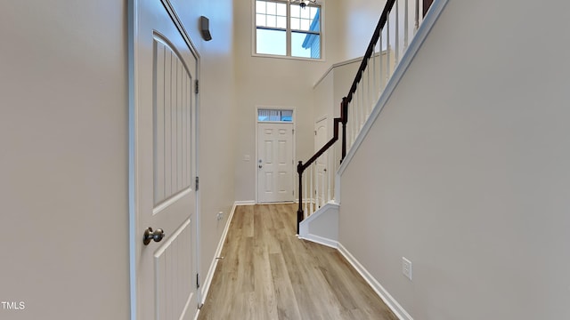 entrance foyer with a towering ceiling and light hardwood / wood-style flooring