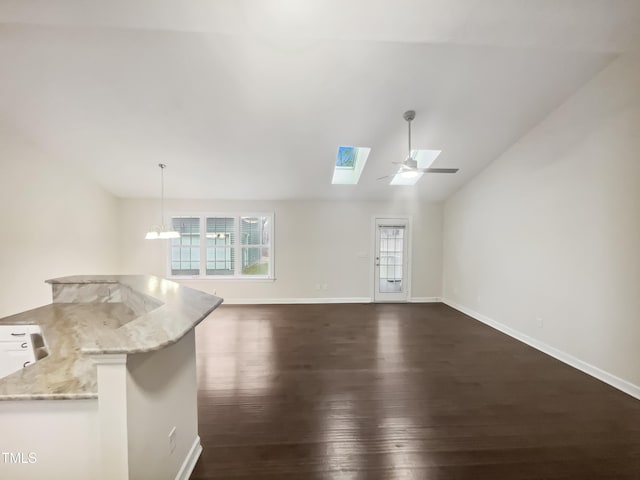 unfurnished living room with lofted ceiling with skylight, dark wood-type flooring, and ceiling fan