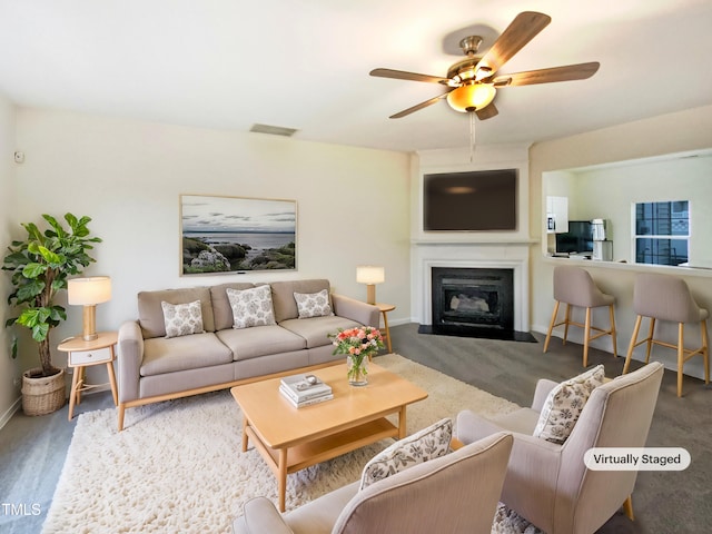 living area with ceiling fan, visible vents, baseboards, and a glass covered fireplace