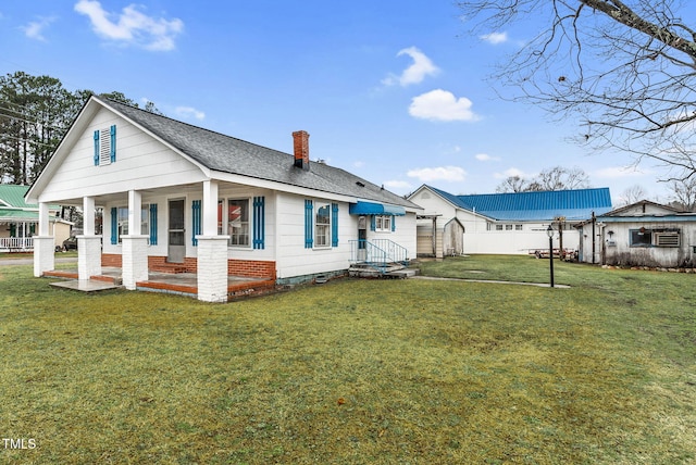 back of property featuring a porch and a yard